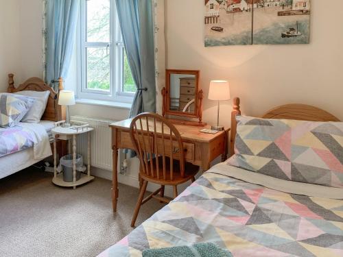 a bedroom with a desk and a bed and a mirror at Middle Cottage in Thirsk
