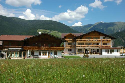a group of buildings with mountains in the background at Alpenhof Wolayersee in Birnbaum