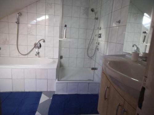 a bathroom with a shower and a tub and a sink at Ferienwohnung Kirchblick - b51898 in Langenbrand