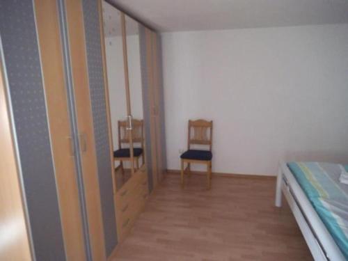 um quarto com uma cama e duas cadeiras em Ferienwohnung Kirchblick - b51898 em Langenbrand