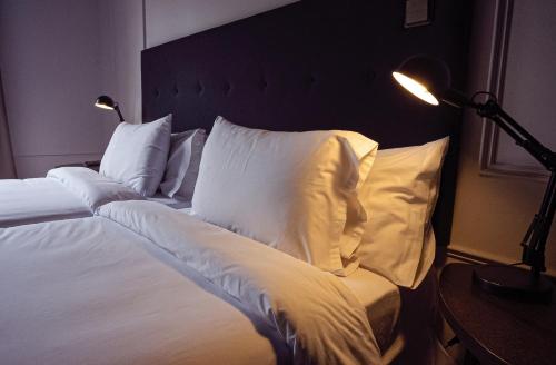 a bedroom with a bed with white pillows at Hotel Hita "Nature Experience" for all in Navacerrada
