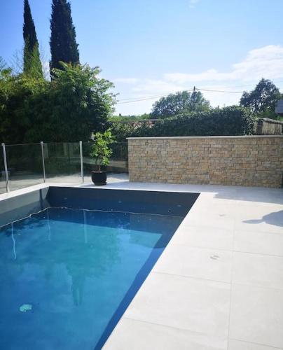 une piscine avec de l'eau bleue dans une cour dans l'établissement Maison tout confort en garrigue, à Boisseron