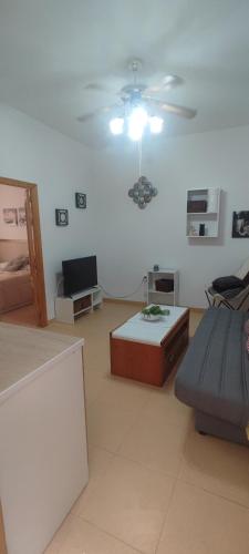 een woonkamer met een bank en een plafondventilator bij Apartamento en el corazon de Triana in Sevilla