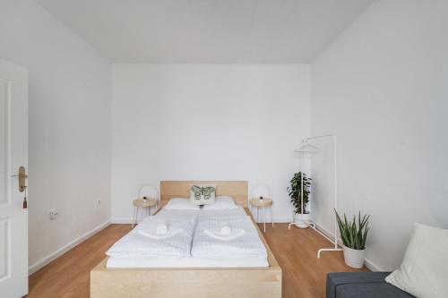ein weißes Zimmer mit einem Bett und einem Sofa in der Unterkunft Cosy Central Studio in Wien