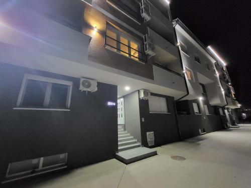 a building with a door and stairs on it at night at Apartman LALA in Sremska Mitrovica