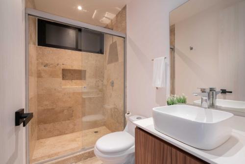 a bathroom with a toilet and a sink and a shower at 2BD with Rooftop Pool near Beach in Tulum