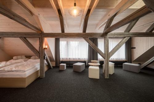 a attic room with a bed and some chairs at Stará škola - Alte Schule, Loučná in Jindřichovice