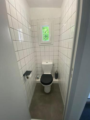 Elle comprend une petite salle de bains pourvue de toilettes et d'une fenêtre. dans l'établissement La maisonnette, à Franconville