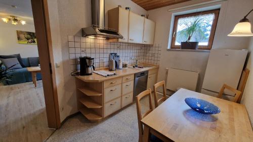 cocina con mesa de madera, mesa y sillas en Haus Luise en Bad Hindelang