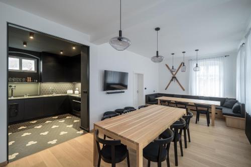 a dining room and kitchen with a wooden table and chairs at Stará škola - Alte Schule, Loučná in Jindřichovice