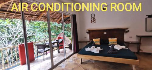 a bedroom with a bed and a balcony at Sulu Sunset Beach Resort in Nauhang