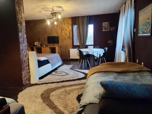 a bedroom with a bed and a dining room with a table at Etno selo naša avlija in Blace