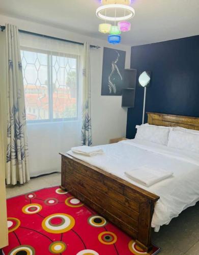 Schlafzimmer mit einem großen Bett und einem roten Teppich in der Unterkunft Sandrock Residence in Nairobi