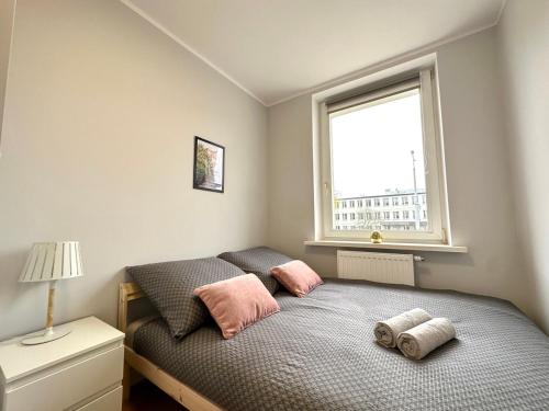 1 dormitorio con 1 cama con 2 almohadas y ventana en MMRent Florence Room, en Gdansk