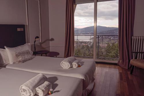 a hotel room with a bed and a large window at Hotel Hita "Nature Experience" for all in Navacerrada