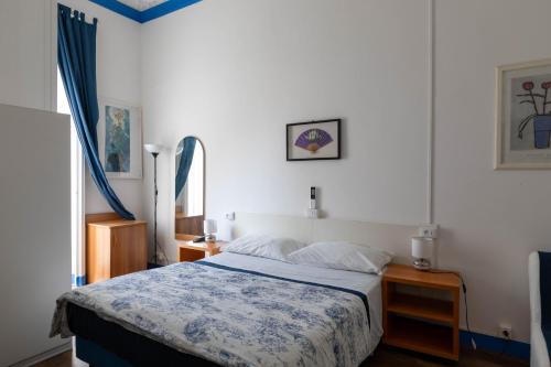 a bedroom with a bed with a blue and white blanket at Olympia Hotel in Genova