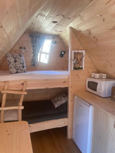 Casa pequeña con cama y microondas en Cabane Insolite Cosy, en Ramonchamp