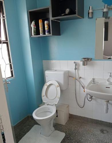 a bathroom with a toilet and a sink at Sandrock Residence in Nairobi