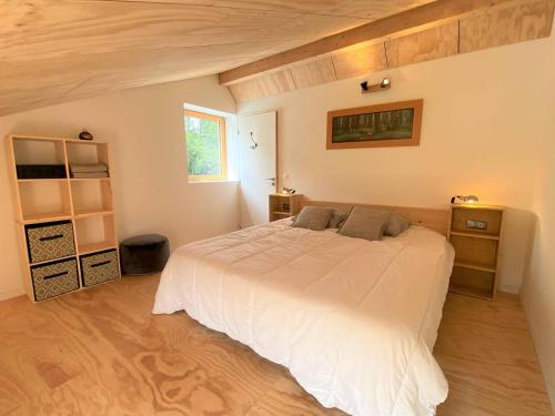 une chambre avec un grand lit blanc et une fenêtre dans l'établissement Villa neuve en bois avec WIFI, jardin à PERROS-GUIREC Ref-847, à Perros-Guirec