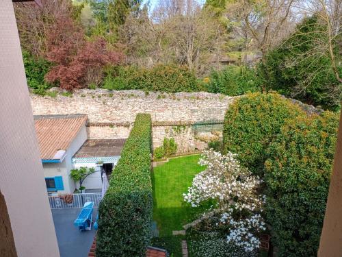 Habitación con vistas a un jardín con arbustos y una pared de piedra. en Casetta Margherita 4 ospiti- Strategic Position, en Bérgamo