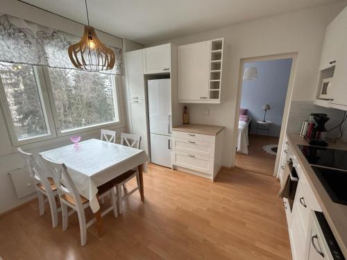 a kitchen and dining room with a table and chairs at Mukkula apartment Lahti 59 m2 in Lahti