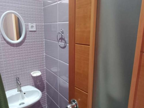 a bathroom with a sink and a mirror at Apartamento T1 in Praia
