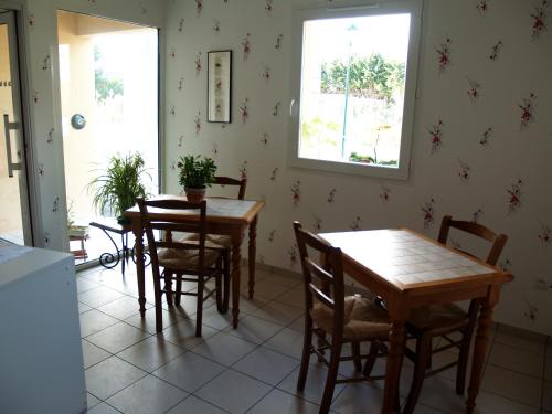 une salle à manger avec deux tables et des chaises dans l'établissement Le Rouge-gorge du Pescofi, à Portet-sur-Garonne