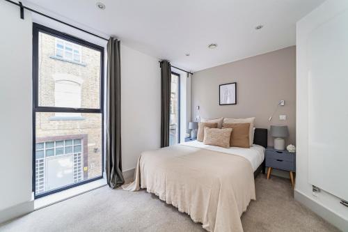 ein Schlafzimmer mit einem Bett und einem großen Fenster in der Unterkunft The Old Street Luxury Flat in London