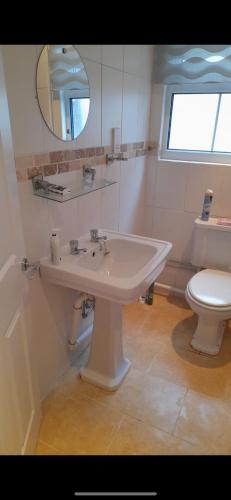 een badkamer met een witte wastafel en een toilet bij Cwtch By The Sea in Porthcawl