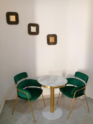Una mesa y cuatro sillas en una habitación en Appartement meublé en Dakar