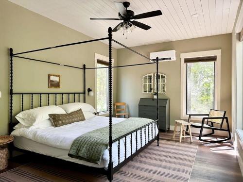 a bedroom with a black canopy bed with a ceiling fan at Brand New Modern Cottage Hocking Hills in Stella