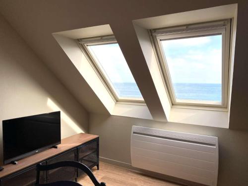Cette chambre dispose de deux fenêtres et d'une télévision à écran plat. dans l'établissement Appartement au dernier étage plage de Trestraou à PERROS-GUIREC - ref 858, à Perros-Guirec