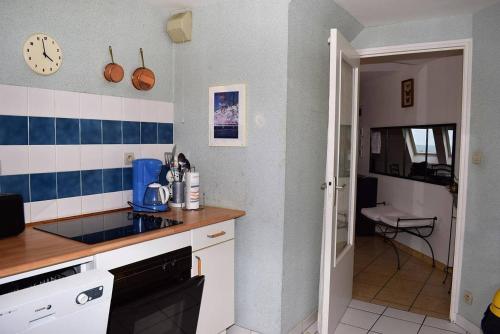 - une cuisine avec du carrelage bleu et blanc sur le mur dans l'établissement Appartement au dernier étage plage de Trestraou à PERROS-GUIREC - ref 858, à Perros-Guirec