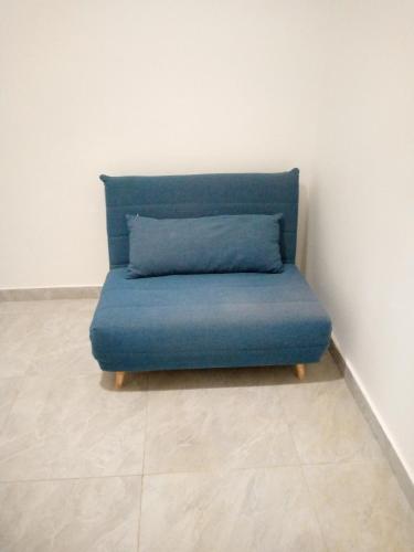 a blue couch sitting in a corner of a room at Appartement meublé in Dakar