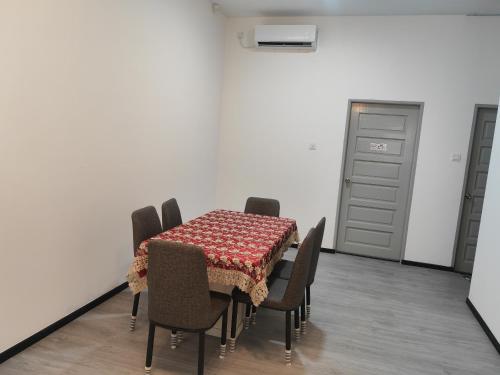 a dining room with a table and chairs and a door at CEM MIRI HOMESTAY in Miri