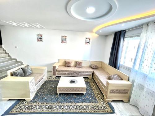 ein Wohnzimmer mit einem Sofa und einem Tisch in der Unterkunft Dar.eJar in Kelibia