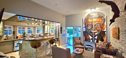 a living room with a large painting of a man at Fleur du Soleil Luxury Guesthouse in Franschhoek