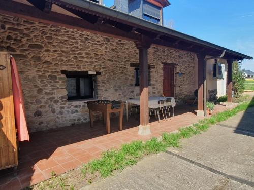 an outdoor patio with a table and a bench at El Bierzo Oro en el Camino in Villaverde de la Abadía