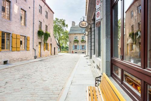 una strada vuota in un centro storico con una panchina di Les Lofts Champlain - Par Les Lofts Vieux-Québec a Québec