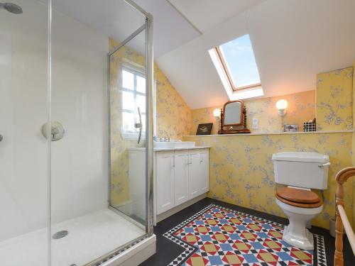 a bathroom with a shower and a toilet and a sink at The Gardeners Cottage in Methven