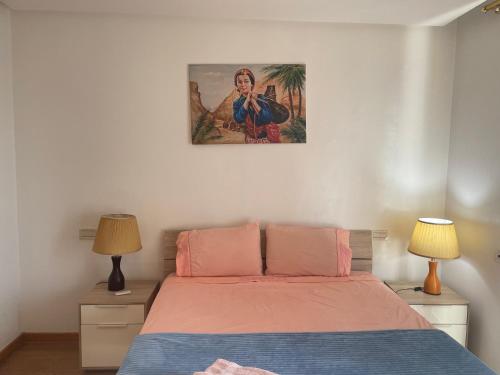 ein Schlafzimmer mit einem Bett und einem Bild an der Wand in der Unterkunft Appartement Casa-marina au 10ème étage in Casablanca