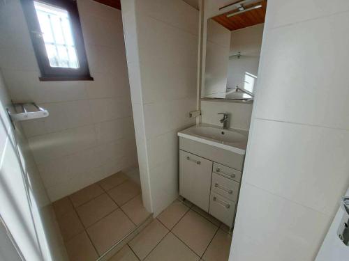 une salle de bain blanche avec un lavabo et un miroir dans l'établissement Spacieuse maison 4 pièces, 8 couchages, terrasse, parking privé, proche Marseillan plages - FR-1-326-420, à Marseillan