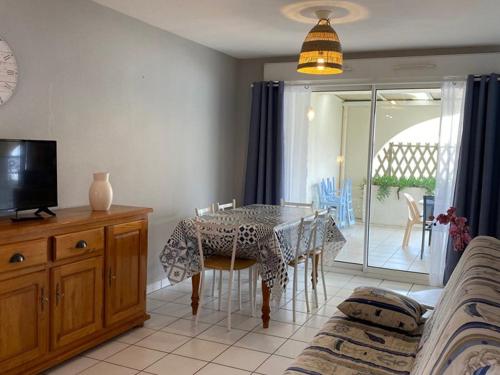 une salle à manger avec une table et une télévision dans l'établissement Appartement T3 à 100m de l'océan avec terrasse, parking et animaux acceptés - Vieux-Boucau - FR-1-379-17, à Vieux-Boucau-les-Bains