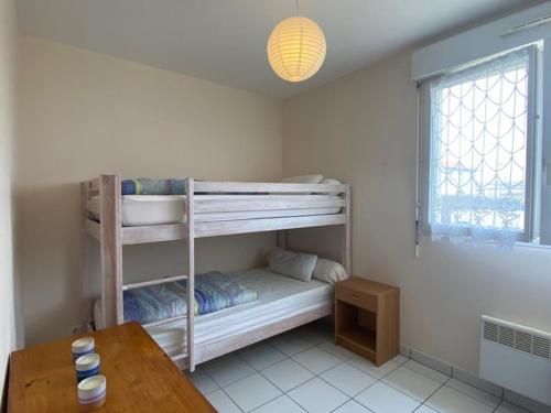 Zimmer mit 2 Etagenbetten und einem Tisch in der Unterkunft Appartement Vieux-Boucau-les-Bains, 3 pièces, 6 personnes - FR-1-379-17 in Vieux-Boucau-les-Bains