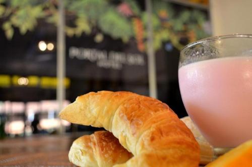聖伊格納西奧的住宿－Portal del Sol，羊角面包和一杯粉红色饮料