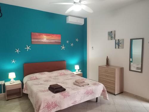 ein Schlafzimmer mit einem Bett und einer blauen Wand in der Unterkunft Bed & Breakfast Gli Alisei in Siniscola