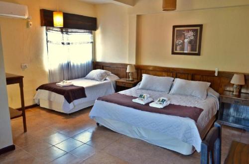 a hotel room with two beds and a window at Portal del Sol in San Ignacio