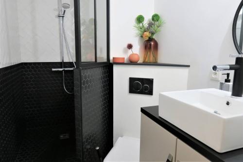 La salle de bains est pourvue d'une douche et d'un lavabo blanc. dans l'établissement Bel Appartement neuf plage de Trestraou à PERROS-GUIREC - Ref 862, à Perros-Guirec