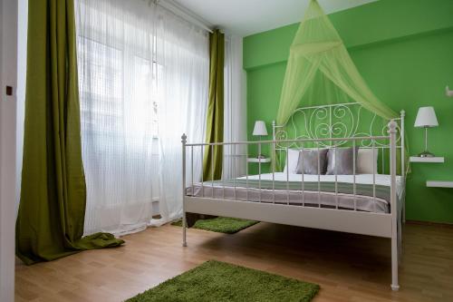 una camera verde con un letto a baldacchino di Sunny Old Town Apartments a Bucarest