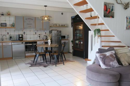 uma cozinha e sala de estar com mesa e cadeiras em Maison de charme avec jardin clos, terrasse à PERROS-GUIREC - Ref 868 em Perros-Guirec